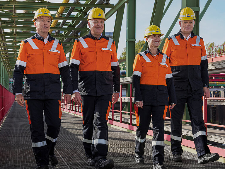 Photo: Aurubis: the entire Executive Board walks onto a site in uniform and yellow helmets